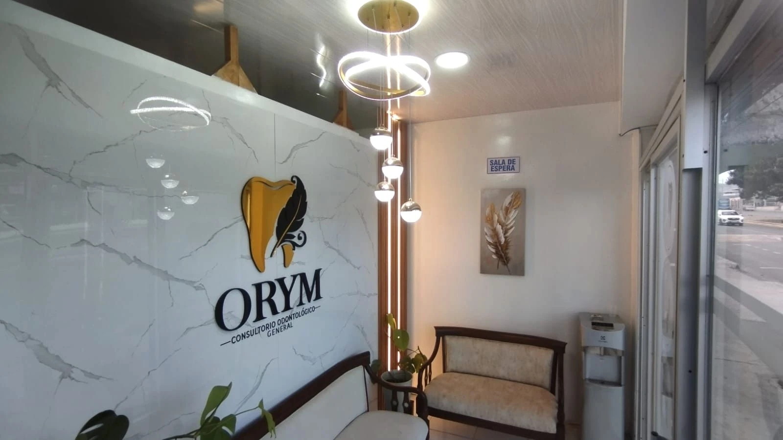 Recepción de ORYM con el logo dorado sobre la pared de mármol